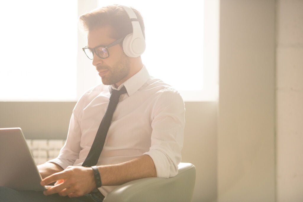 Local SEO Essentials: 3 Key Elements Explained 3 SEO A man using a laptop while wearing headphones.