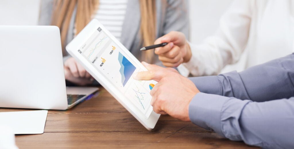 Johannesburg SEO Agency | SEO Services Johannesburg | Your SEO Company for Marketing Growth 2 SEO A group of people sitting at a table looking at a tablet.